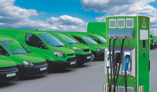 Green EV vans charging at charging station